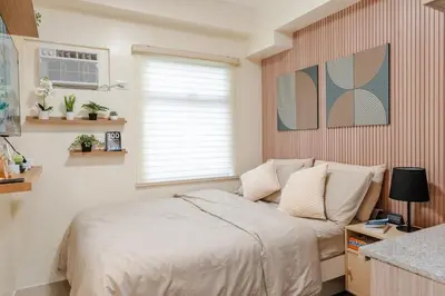 a small bedroom with a bed and a window at SSM Staycation in Manila