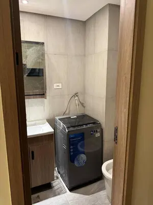 a bathroom with a washing machine and a toilet at Condotel by Heidi in Manila