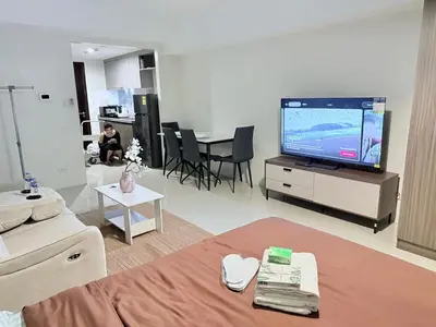 a living room with a tv and a couch and a table at pocco homestay in Manila