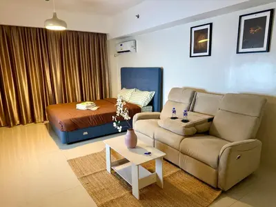 a living room with a couch and a bed at pocco homestay in Manila