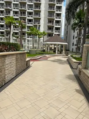 a walkway in a city with palm trees and buildings at Solemare Parksuites - no balcony in Manila