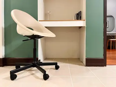 a white office chair sitting in a room at Spacious 1BR with 300MBPS Internet near High Street BGC in Manila