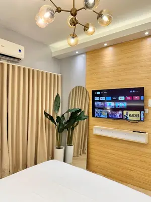 a bedroom with a bed and a flat screen tv at Stylish Studio Unit with Balcony in Grace Residences in Manila