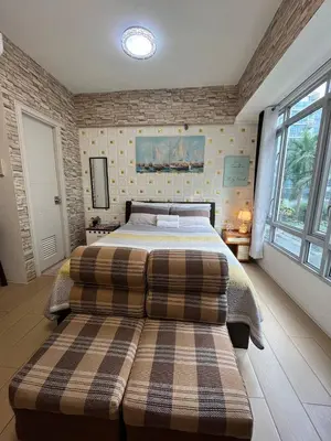 a bedroom with two beds and a large window at Marvinn's by LVH - 150 Newport Boulevard in Manila