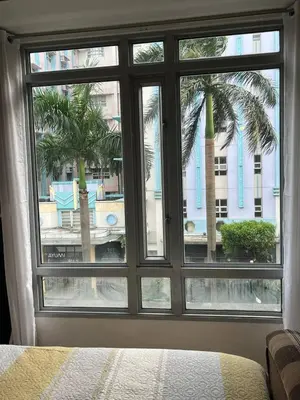 a bedroom window with a view of a palm tree at Marvinn's by LVH - 150 Newport Boulevard in Manila