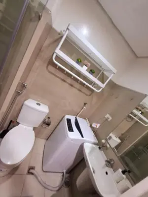 a bathroom with a white toilet and a sink at Sam's crib staycation in Manila