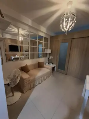a living room with a couch and a chandelier at Sam's crib staycation in Manila