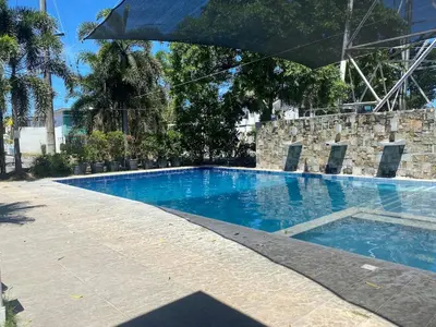 a large swimming pool with an umbrella over it at Norene Bianca Staycation in Carmona