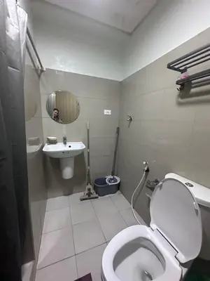a bathroom with a toilet and a sink and a mirror at Shore 2 tower 1 by Richnells cozy Oasis in Manila