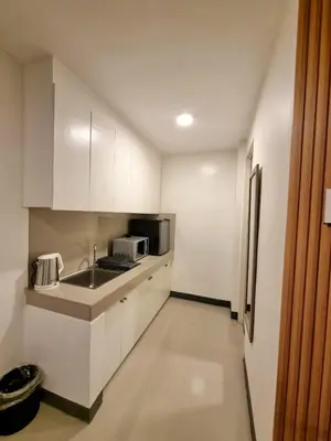 a white kitchen with a sink and a microwave at Flat 35, Unit 1C in Manila