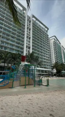 a large building on the beach next to a beach at Azure residences by Amóre Suites in Manila