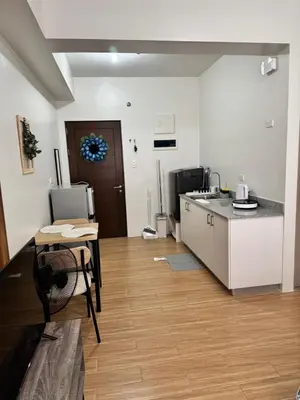 a kitchen and dining room with a table and a counter at Mels Place at Tulip Garden Condominium Southwoods in Biñan
