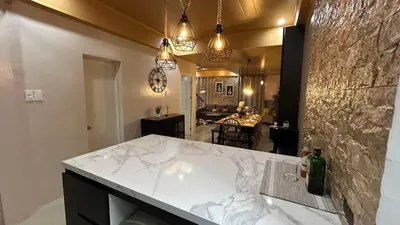 a kitchen with a marble counter top and a dining room at The Grand Escape - Suntrust Verona, Silang Cavite in Silang