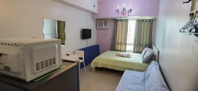 a small room with a bed and a tv at OYO 1172 MVM Transient House in Manila