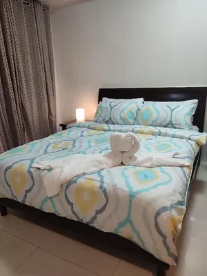 a bedroom with a bed with a stuffed animal on it at Kmad's Condotel in Manila