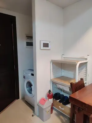 a laundry room with a washing machine and a table at Kmad's Condotel in Manila