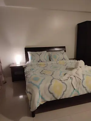 a bedroom with a bed with a blue and yellow comforter at Kmad's Condotel in Manila