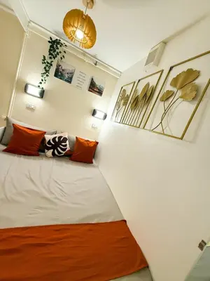 a room with a bed with orange and white pillows at Twins Nest - CASA VICENTE Cozy 2-Bedroom Loft Condo Mandaluyong in Manila