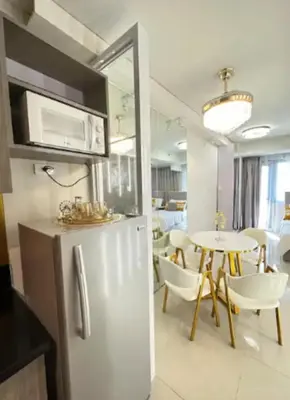 a kitchen with a refrigerator and a table with chairs at Sweet Escape at S Residences in Manila