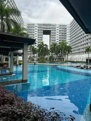 a large swimming pool in front of a large building at Wheng Place at Shell Residences MOA in Manila