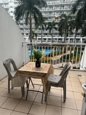 a table and chairs on a balcony with a view of a building at Wheng Place at Shell Residences MOA in Manila