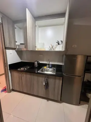 a kitchen with a sink and a refrigerator at Good Luck House at S RESIDENCES in Manila