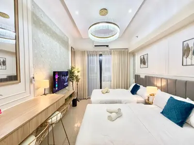 a hotel room with two beds and a television at ClaySky Staycation at Shore 2 Residences Tower 2 near Mall of Asia- Hotel Set Up in Amenity and Pool Level with Netflix, HBO Max & Youtube Premium in Manila