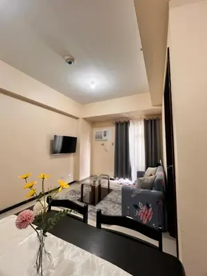 a living room with a couch and a tv at Radiance Manila Bay Bayview Comfort with Pool & Pet-Friendly in Manila