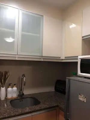a kitchen counter with a sink and a microwave at Estancias De Sofielo in Manila