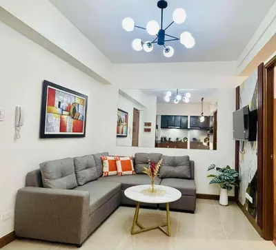 a living room with a couch and a table at Palm Beach West - Baler Tower in Manila