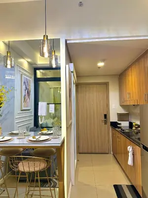 a kitchen with a counter with chairs and a table at Golden Sunset Suite in Manila