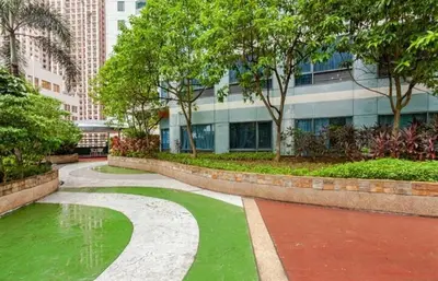 a park with green grass and a building at Spectacular Penthouse with Stunning Balcony in Eastwood Mall in Manila