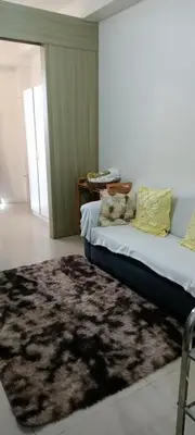 a living room with a bed and a rug at Like home staycation in Manila