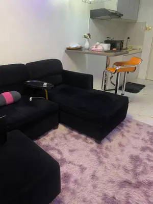 a living room with a black couch and a purple rug at Elegant Golden Loft with Mood Lighting Central Location and Skyline Views in Manila