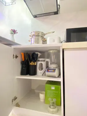 a kitchen shelf with a blender and other kitchen utensils at Elegant Golden Loft with Mood Lighting Central Location and Skyline Views in Manila