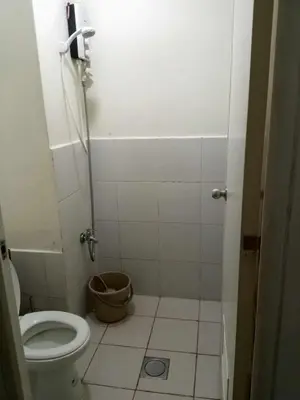 a small bathroom with a toilet and a shower at Zafreen Condotel in Manila