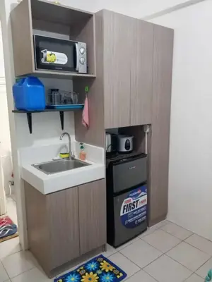 a small kitchen with a sink and a microwave at Zafreen Condotel in Manila