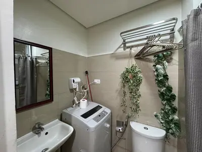 a bathroom with a toilet and a sink and a mirror at 640 Coffee Room Shore 2 Residences MOA Pool View by Prime Stay in Manila