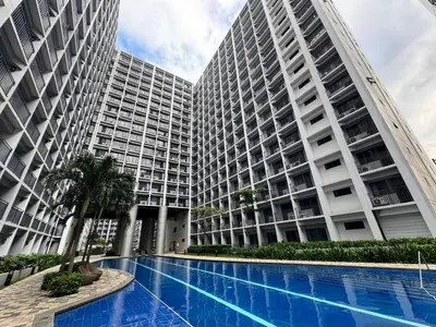 a large building with a swimming pool in front of it at 1645 Coffee Room Shore 2 Residences Pool View by Prime Stay MOA in Manila