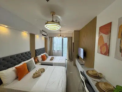 a hotel room with two beds and a tv at Shore 2 Residences RM 19106 Pool View by Prime Stay MOA in Manila