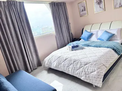 a bedroom with a bed with blue pillows and a window at H Cloud Suites Monarch Parksuites near MOA and Casino City in Manila