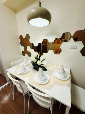 a dining room with a white table and chairs at The Camden Place 1BR Condo Apartment in Manila