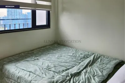 a bed in a room with a window at City View Staycation Near Mall of Asia and Airport in Manila