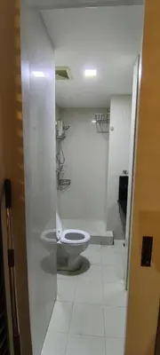 a white bathroom with a toilet in a room at Greenbelt Excelsior in Manila