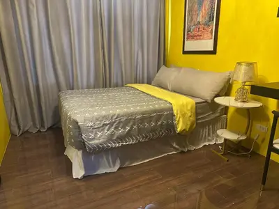 a bedroom with a bed and a yellow wall at Cozy Escape by Dave 4563 in Manila