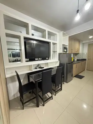 a kitchen with a table with chairs and a flat screen tv at Shore 1 residences Tower D Pasay City in Manila