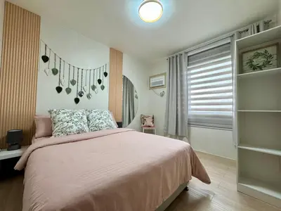 a bedroom with a pink bed and a window at A and A Place - The Hive C - Free Parking in Taytay