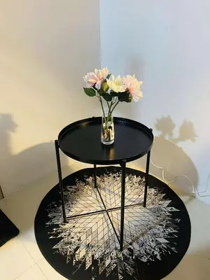 a black table with a vase with flowers on it at Cozy haven across terminal 3 in Manila
