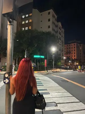 a woman with red hair standing on a city street at Cozy haven across terminal 3 in Manila