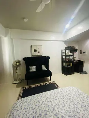 a bedroom with a bed and a chair at Cozy Haven Across Terminal 3 in Manila